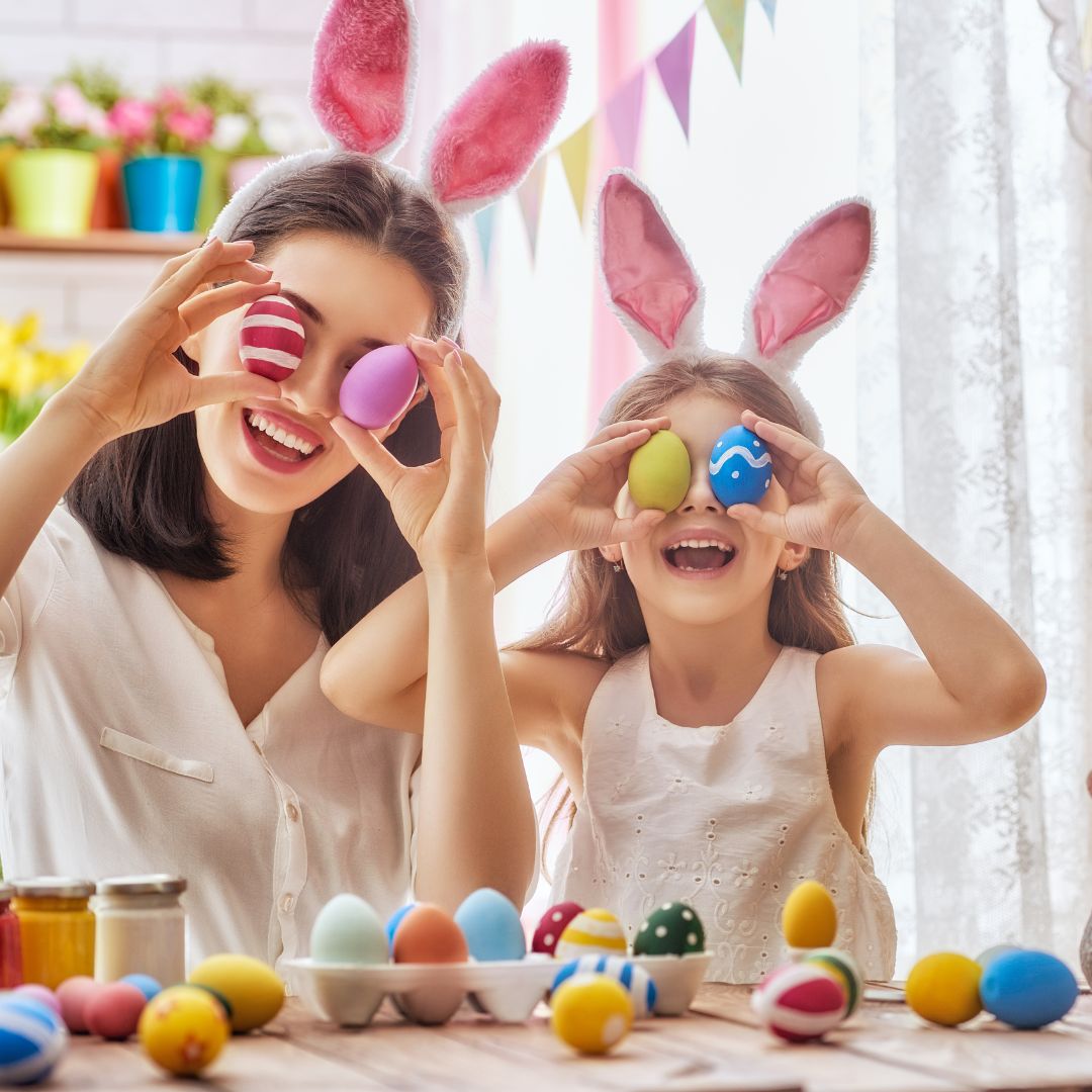 Mãe e filha com ovos coloridos de Páscoa